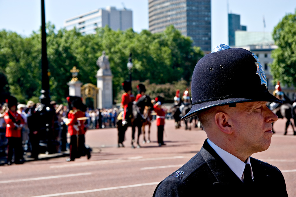 I had been in London for all of about two hours (time enough to get to my hotel and and have a shower) when I decided to go for a walk in Green Park towards the palace. When I got there I found huge security and vast groups of tourists. Seems that the horse guards were rehearsing for something big in the next week. Despite the security there was an almost festival atmosphere with tourists (myself included) taking an unexpected chance for a sneak preview. Even the police, while watchful seemed in the mood. Except for this guy who seemed to be able tune out everything except his job. I liked the juxtaposition of him and the pageantry behind.