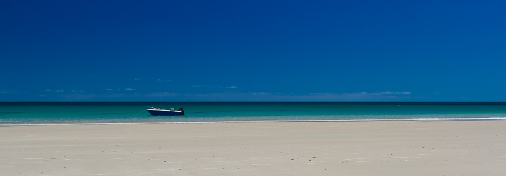 Treking along the beach with friends to look at some jetty ruins and we all noticed this lone boat moored nearby. I could resisit cropping the image to a broad panorama.